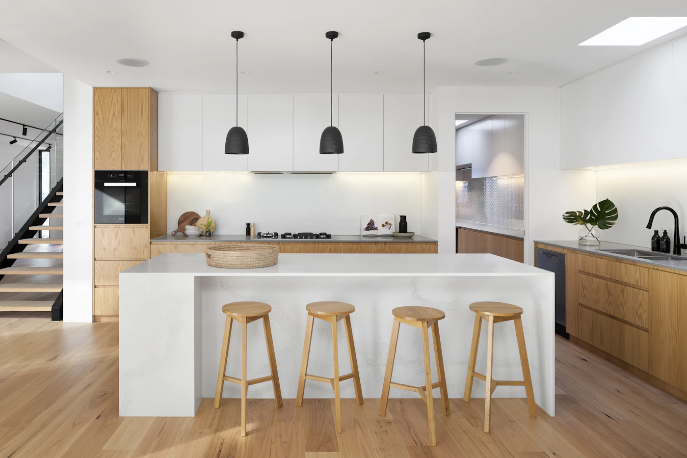 Bright contemporary kitchen with natural wood cabinetry and a broad island