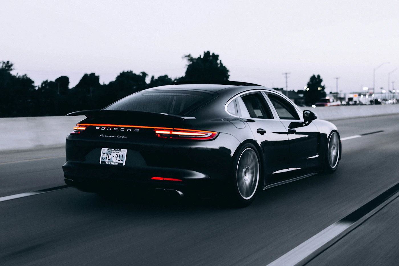 Glossy black performance sedan photographed on the road