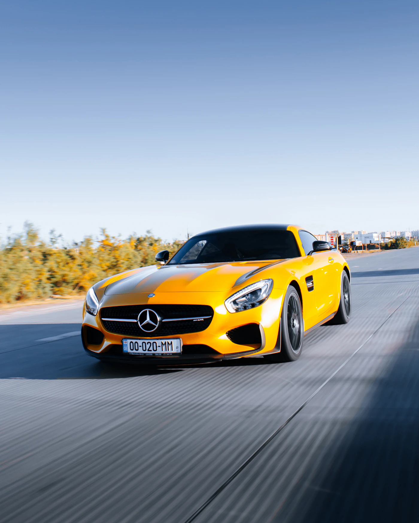Yellow sports car with reflective paint in motion